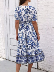 Back view of the blue and white floral puff-sleeve midi dress with a gathered waist.