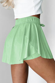 Side view of mint green skort showing the flared overlay over fitted shorts