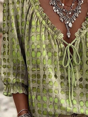 Green printed blouse sleeve and front hem detail.