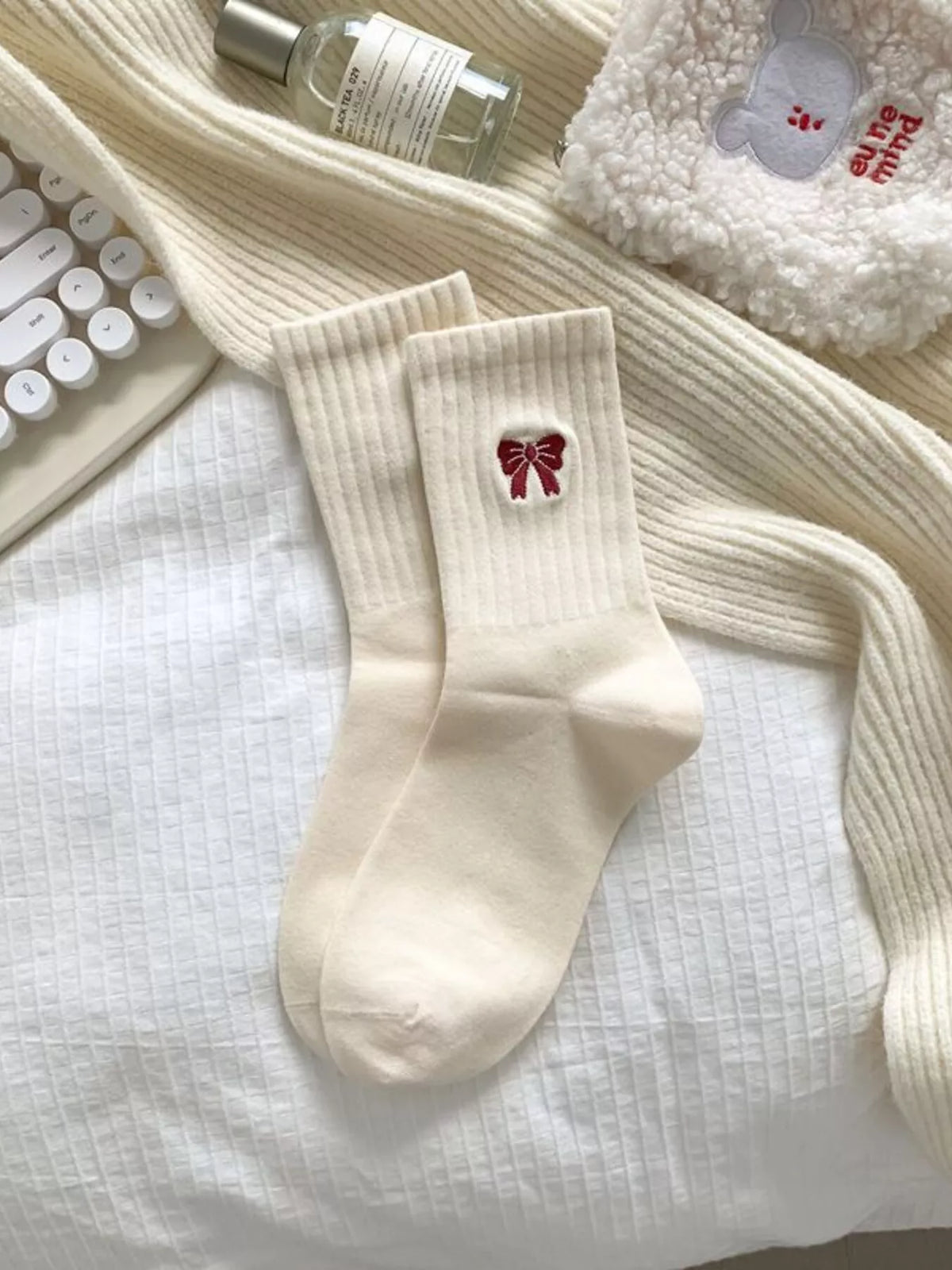 Cream ribbed crew socks with small bow motif laid flat