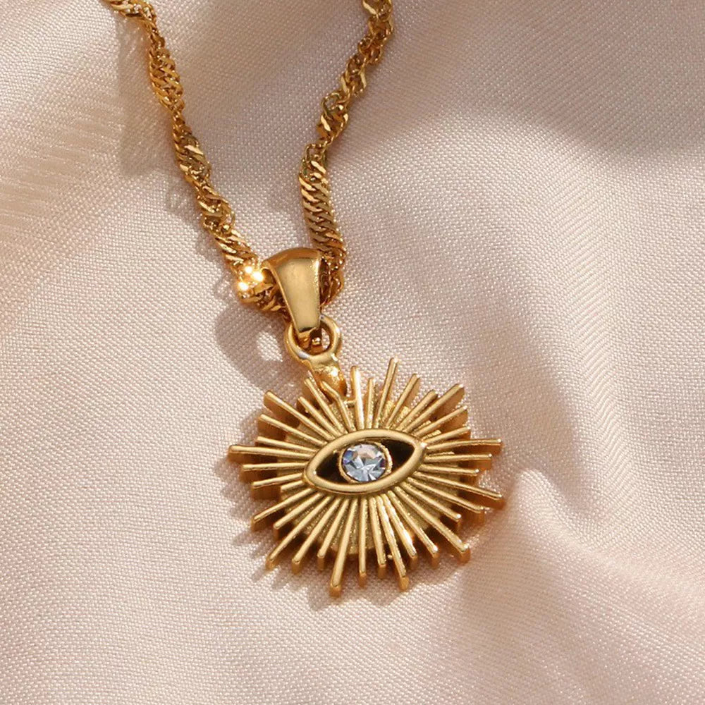 Detailed view of clear stone in gold-tone evil eye sunburst pendant