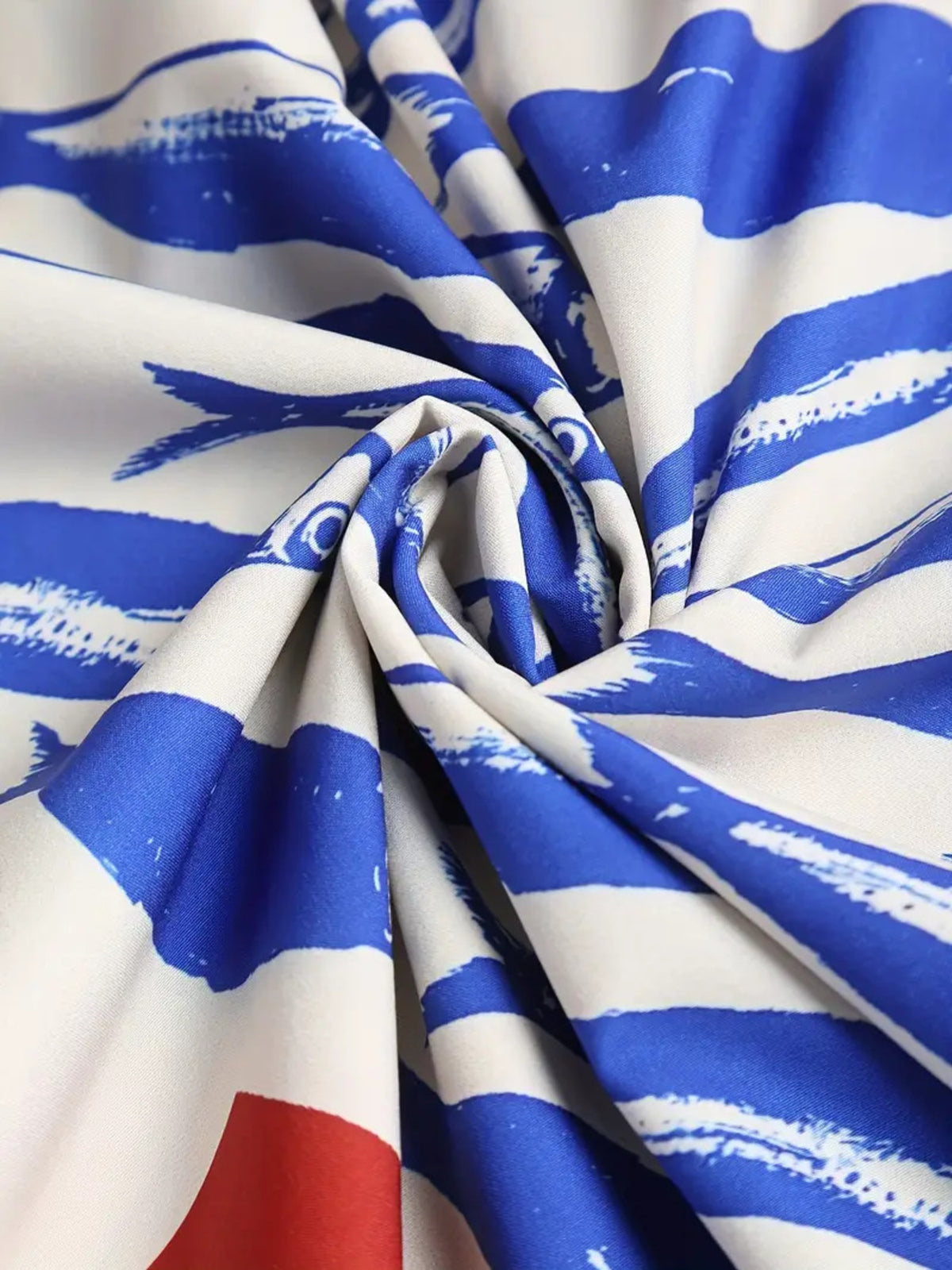 Twisted white dress fabric showing the blue sardine pattern and gathered folds.