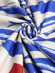 Twisted white dress fabric showing the blue sardine pattern and gathered folds.