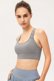 Model wearing gray scoop-neck sports bra, angled front view