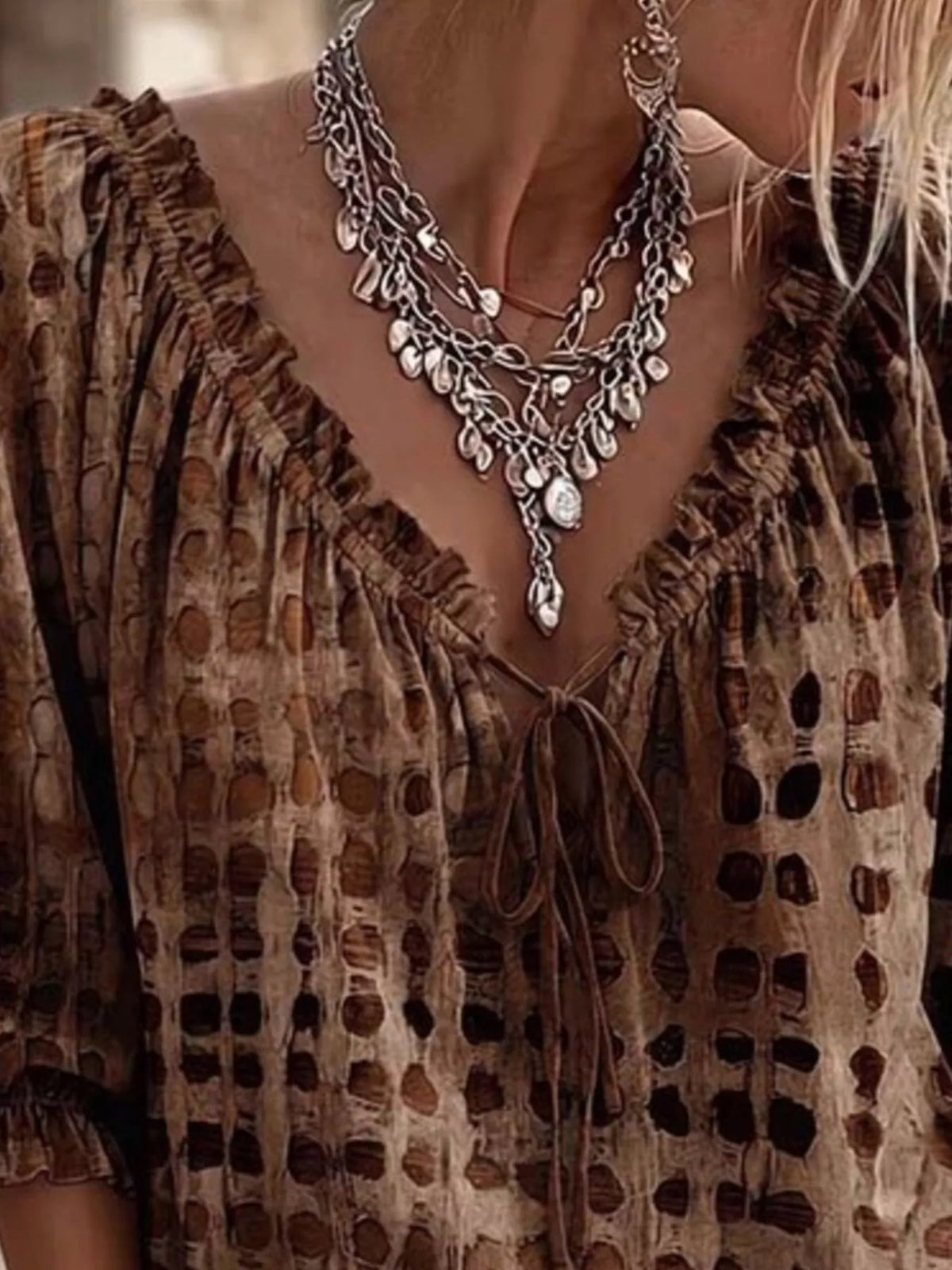Close-up of the brown blouse's gathered neckline and bow ties.