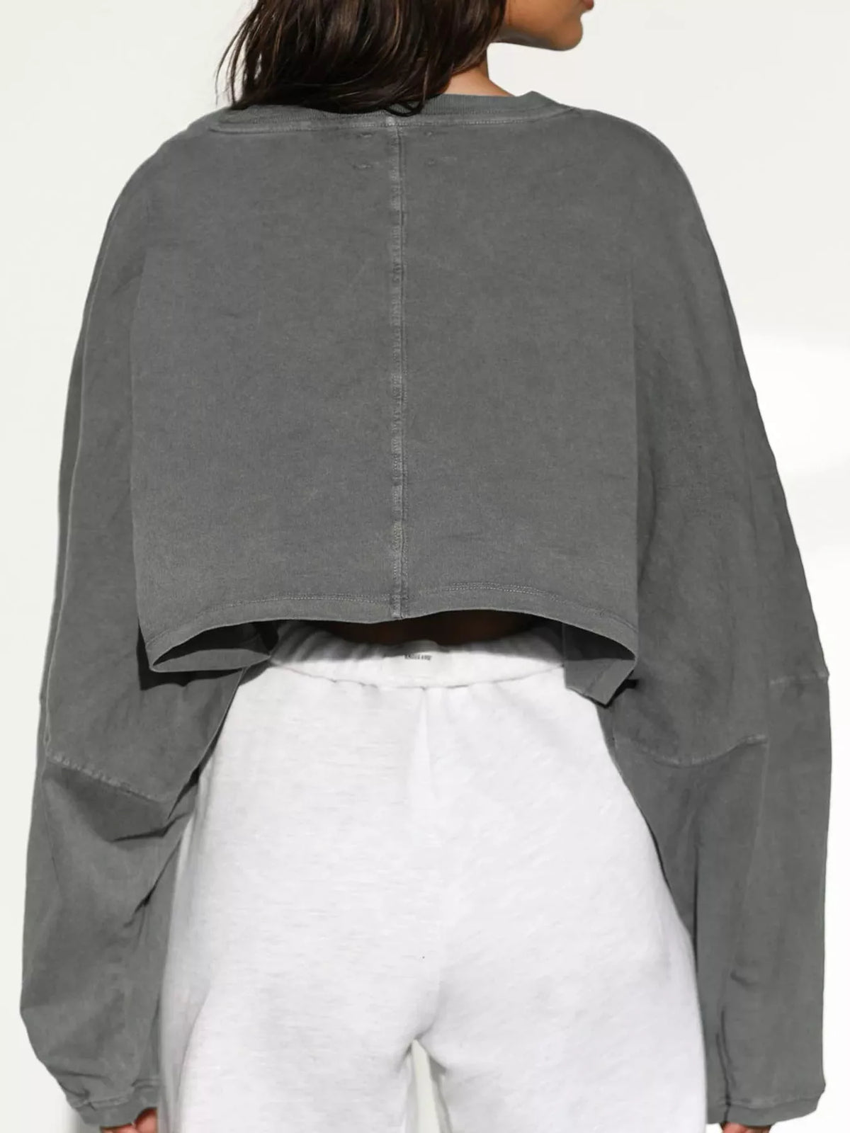 Back view of gray cropped sweatshirt showing center seam and cropped hem