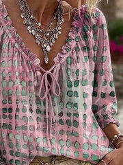 Pink printed blouse shown at an angle with its gathered sleeve and loose hem.