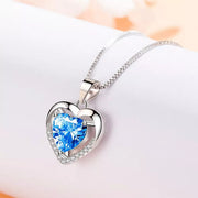 Silver-tone heart necklace with blue center stone on white background