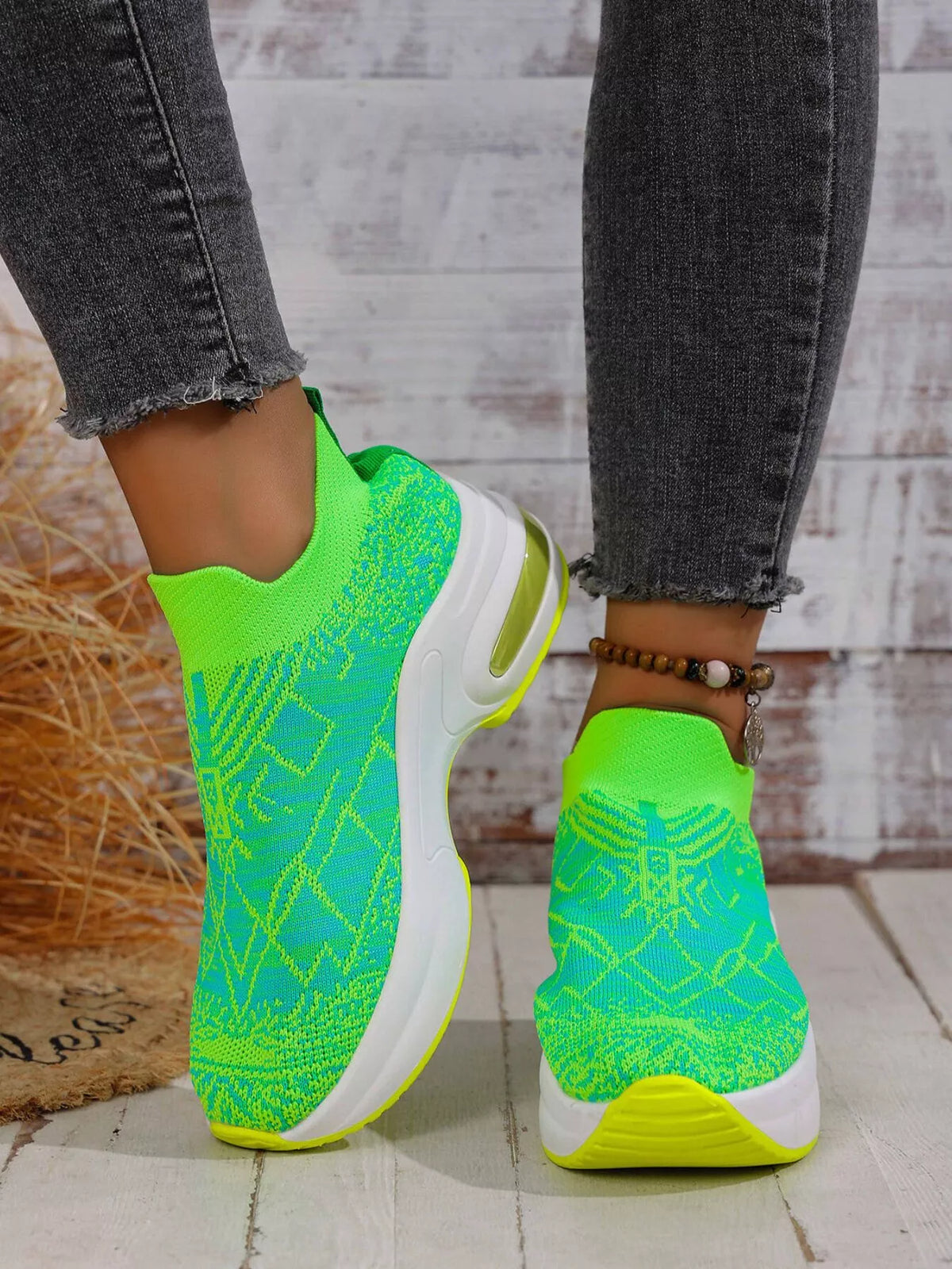 Lime green patterned mesh trainers with white soles worn with cropped dark jeans