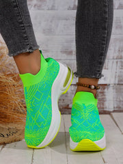 Lime green patterned mesh trainers with white soles worn with cropped dark jeans