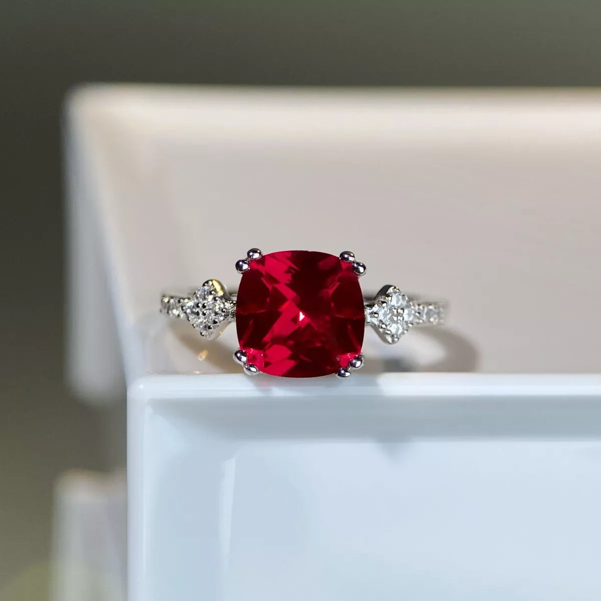 Red rectangular zircon ring photographed from above.