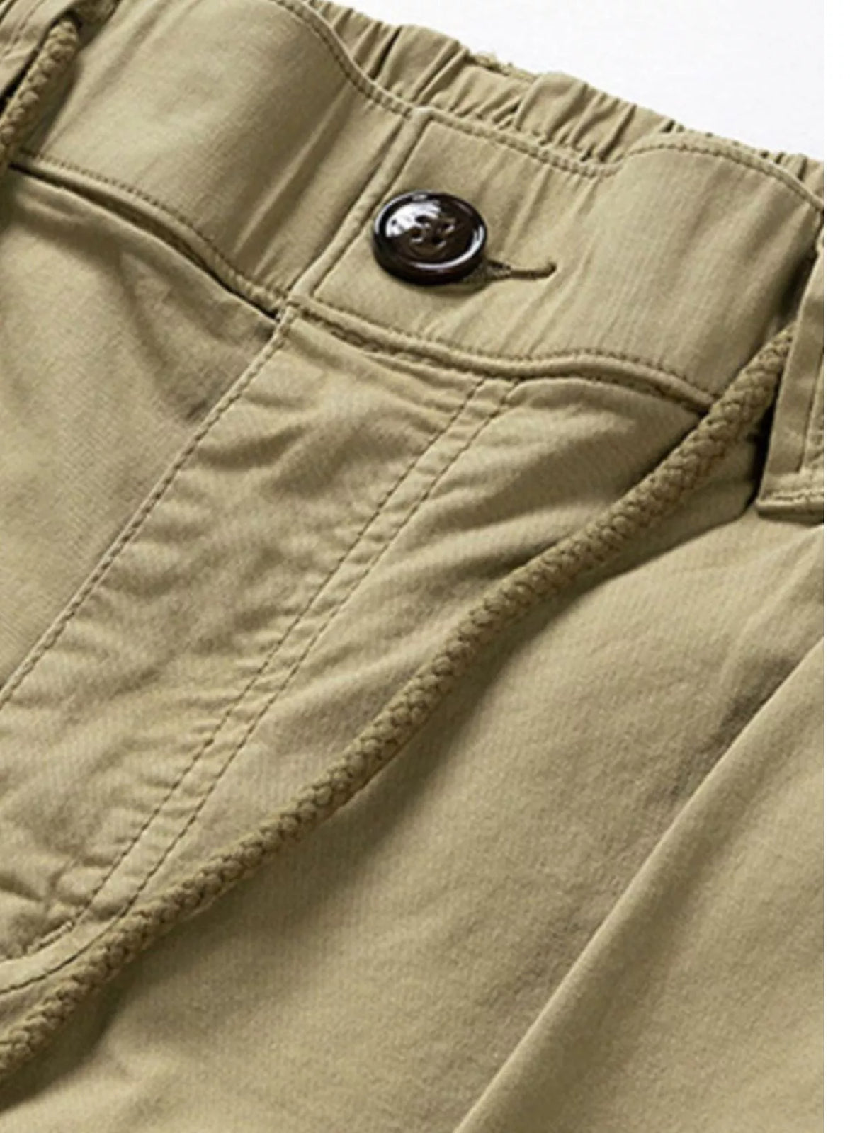 Close-up of khaki cargo pants waistband, button and stitching