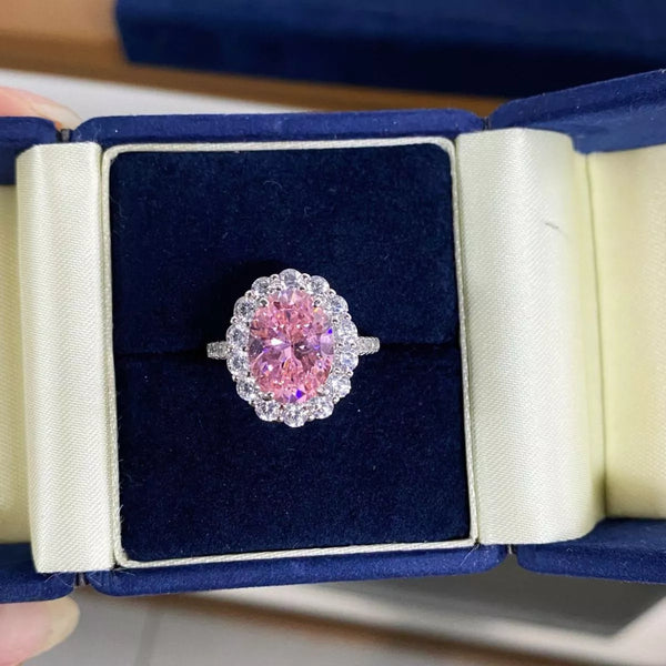 Blush pink oval centre stone ring displayed in its open box.