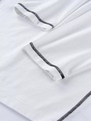 Close-up of black contrast stitching on white long-sleeve T-shirt fabric