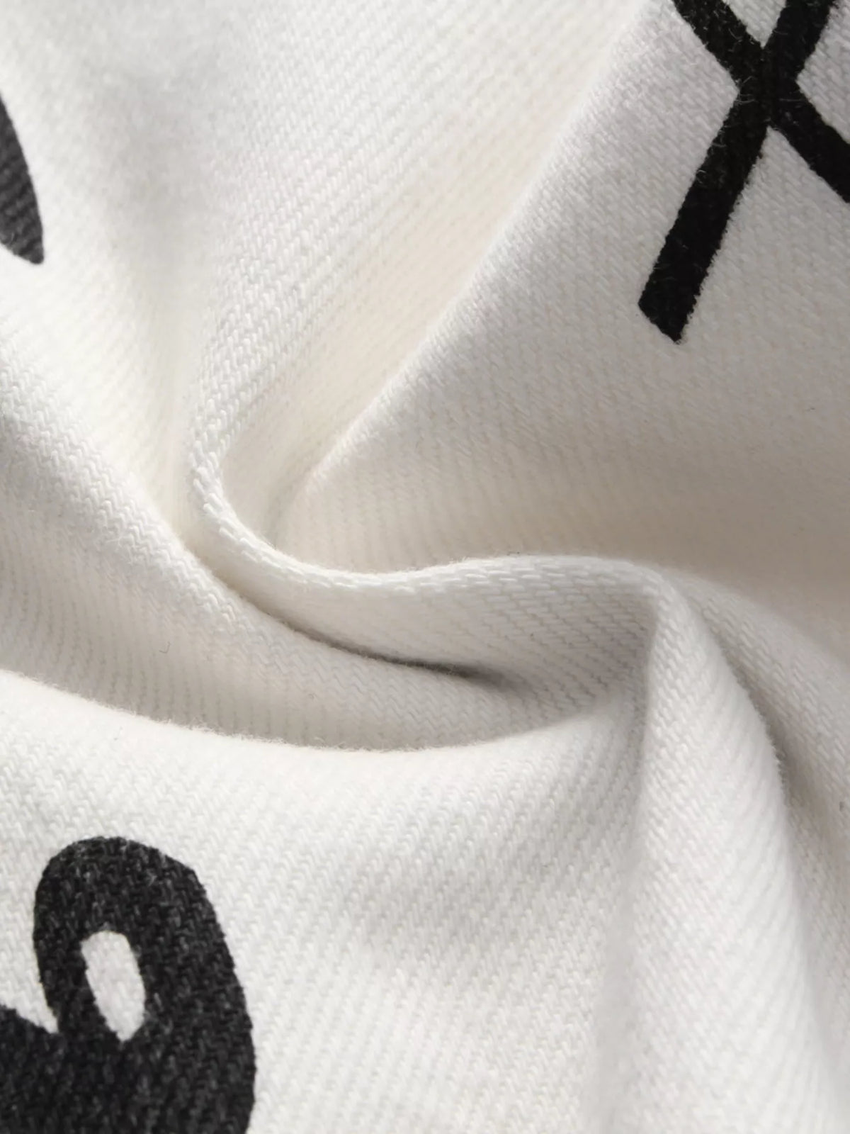Close-up of white denim fabric with black printed marks