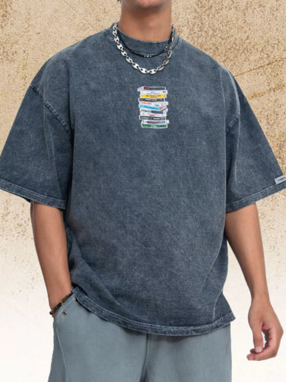 Model wearing the blue vintage-wash graphic T-shirt with hands in pockets