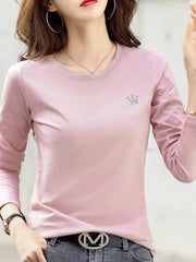 Pink long-sleeve T-shirt with small crown emblem, shown on a model from the front.
