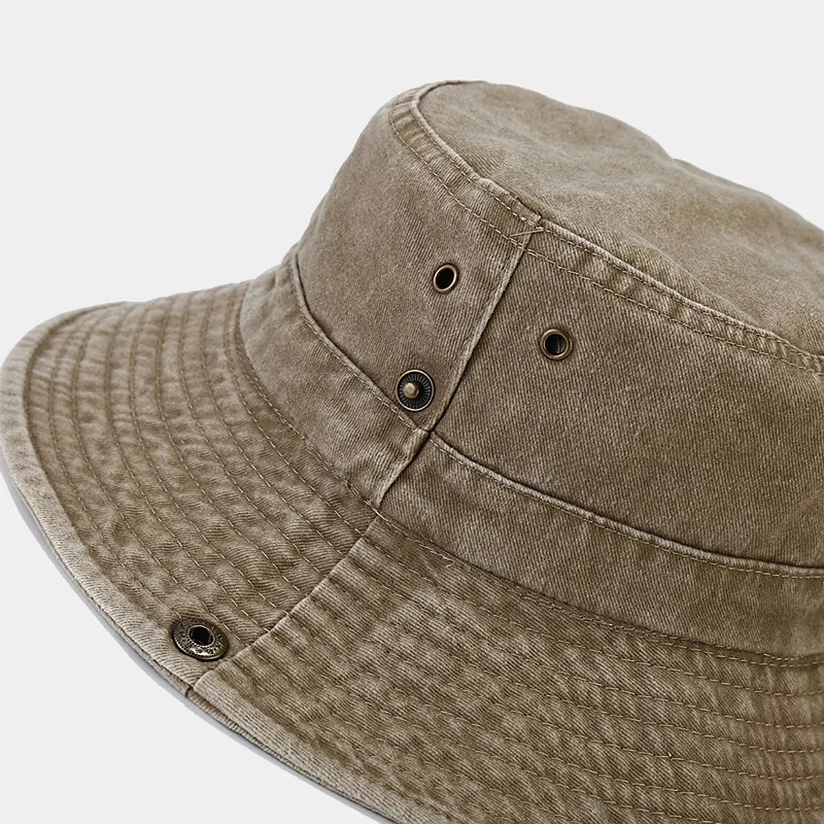 Close-up of metal ventilation eyelets on the camel bucket hat