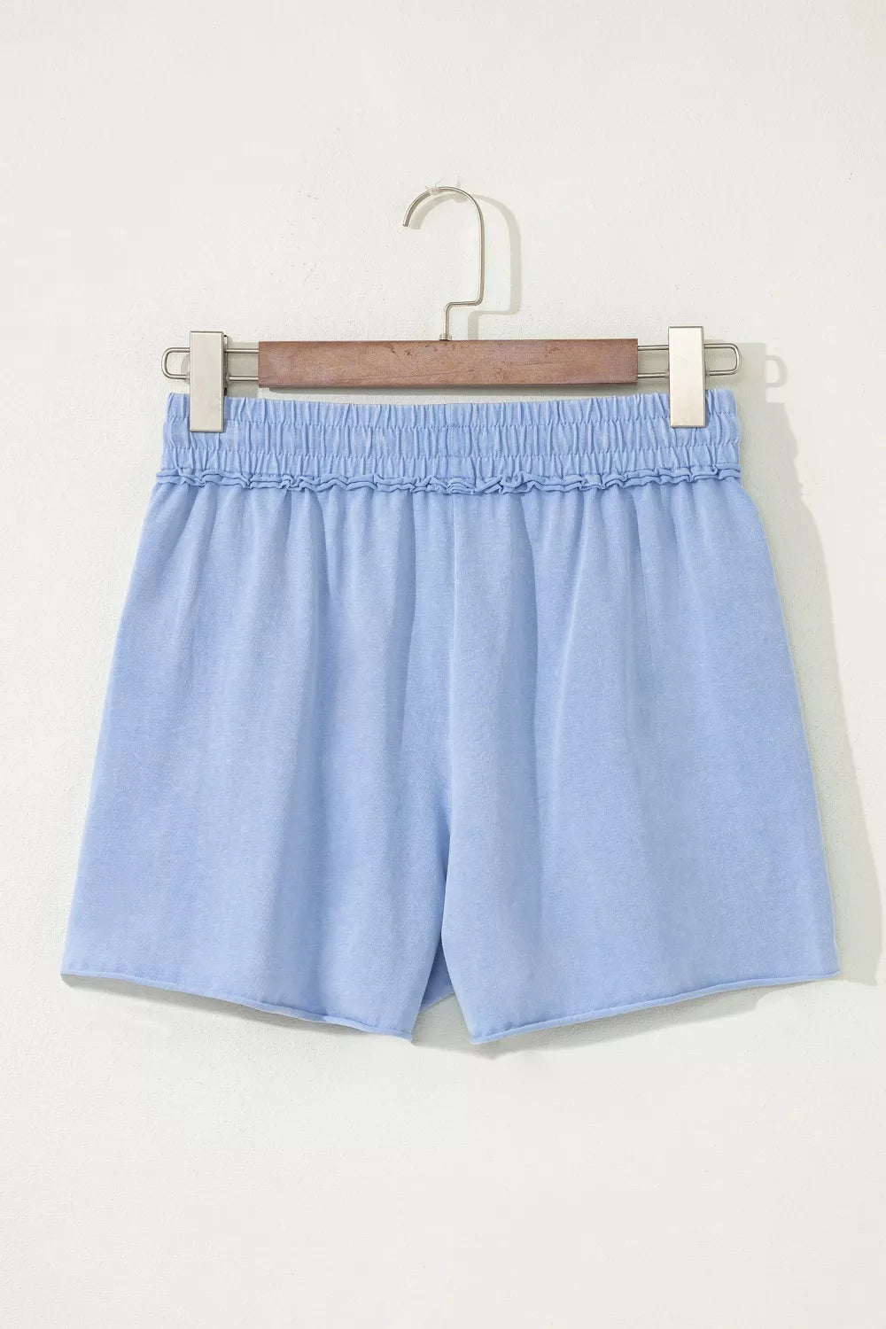 Light-blue drawstring shorts laid flat, front view