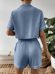 Back view of blue cropped shirt and elastic-waist shorts with white piping