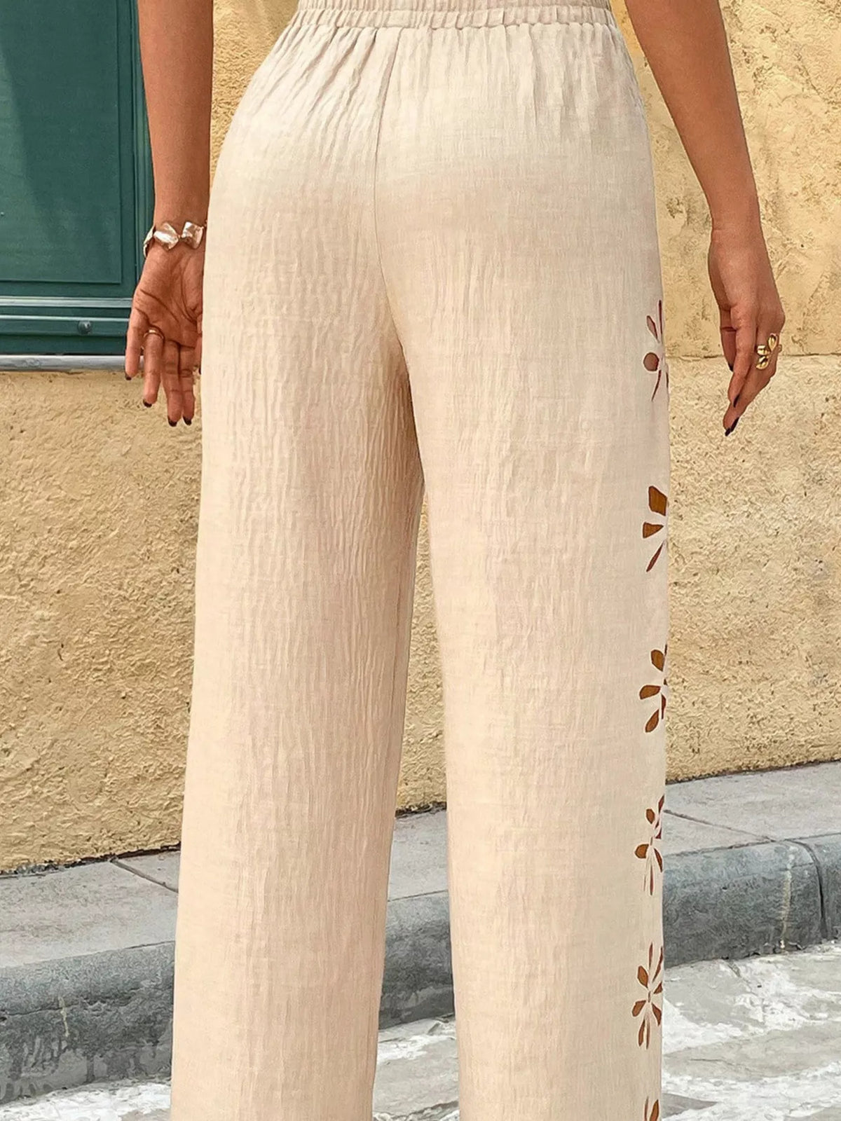 Model wearing navy wide-leg pants with floral cutout embroidery