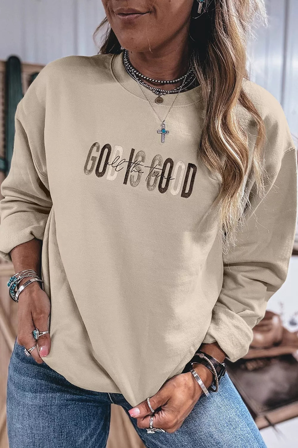 Front view of God Is Good pullover styled with jeans