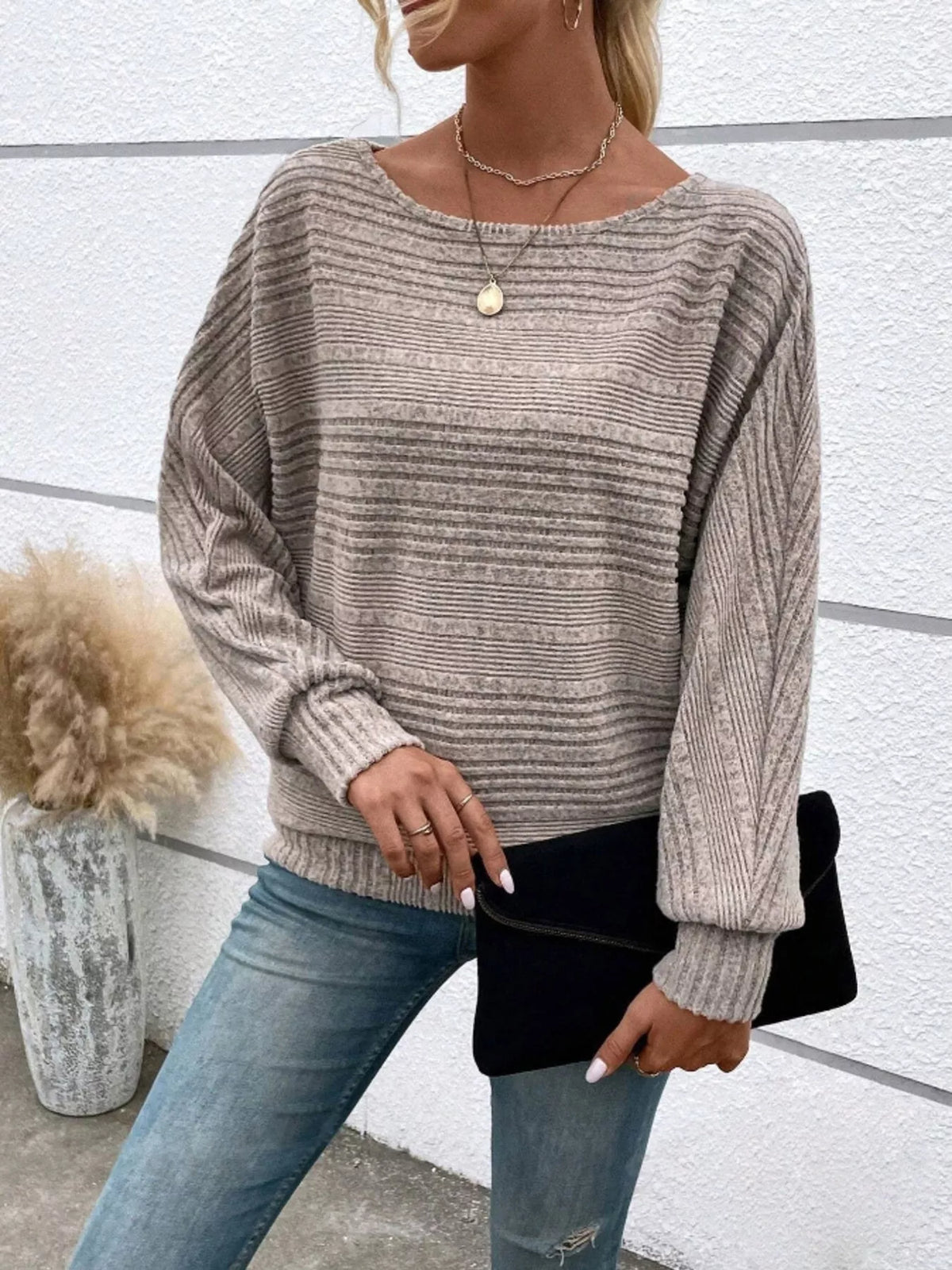 Women’s ribbed round-neck long-sleeve top in taupe front view holding dark clutch