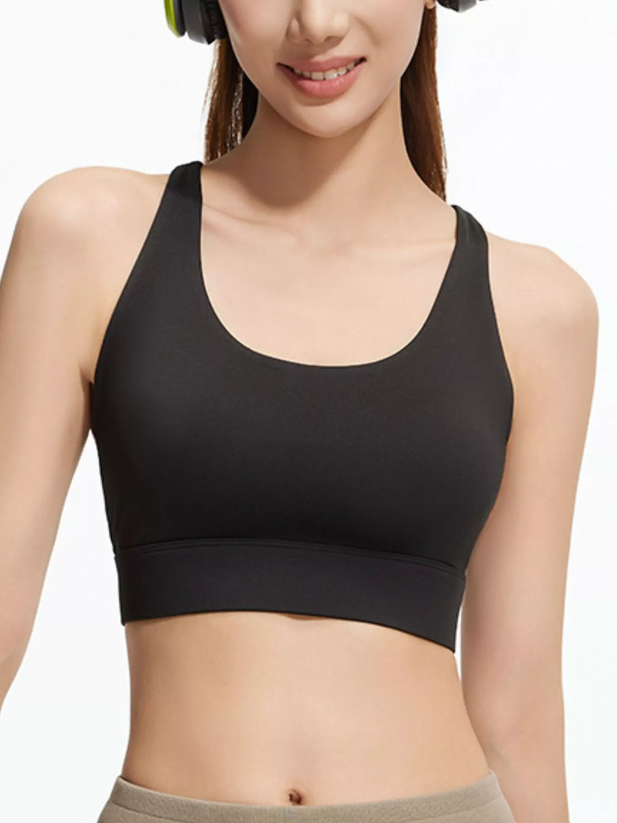 Model wearing black scoop-neck active bra with grey leggings, shown from the front