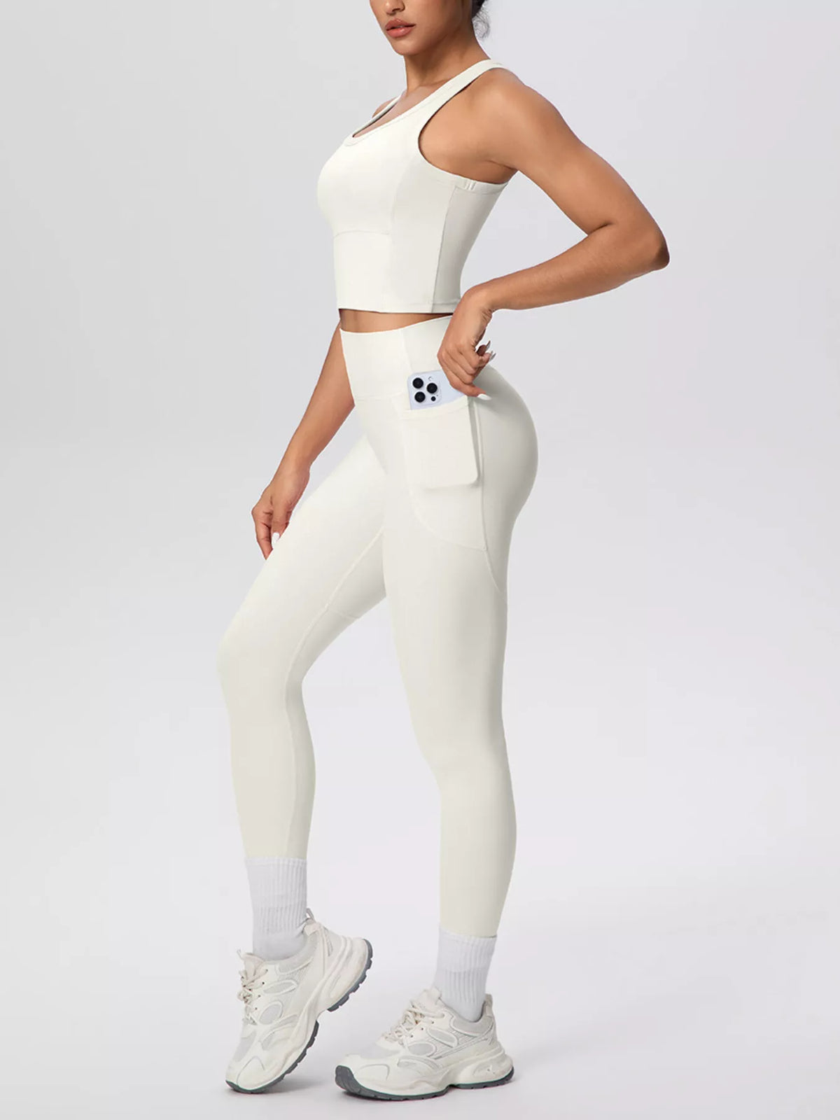 Cream tank and leggings shown from the front with hand at waist