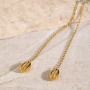 Close view of two gold oval charm drops on the fine chain
