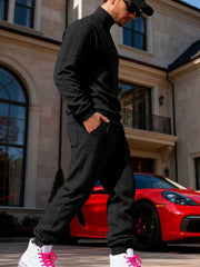 Black cable-knit sweater and joggers shown from the side.