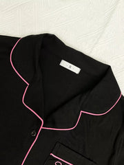 Close-up of black pajama shirt collar and pink piping
