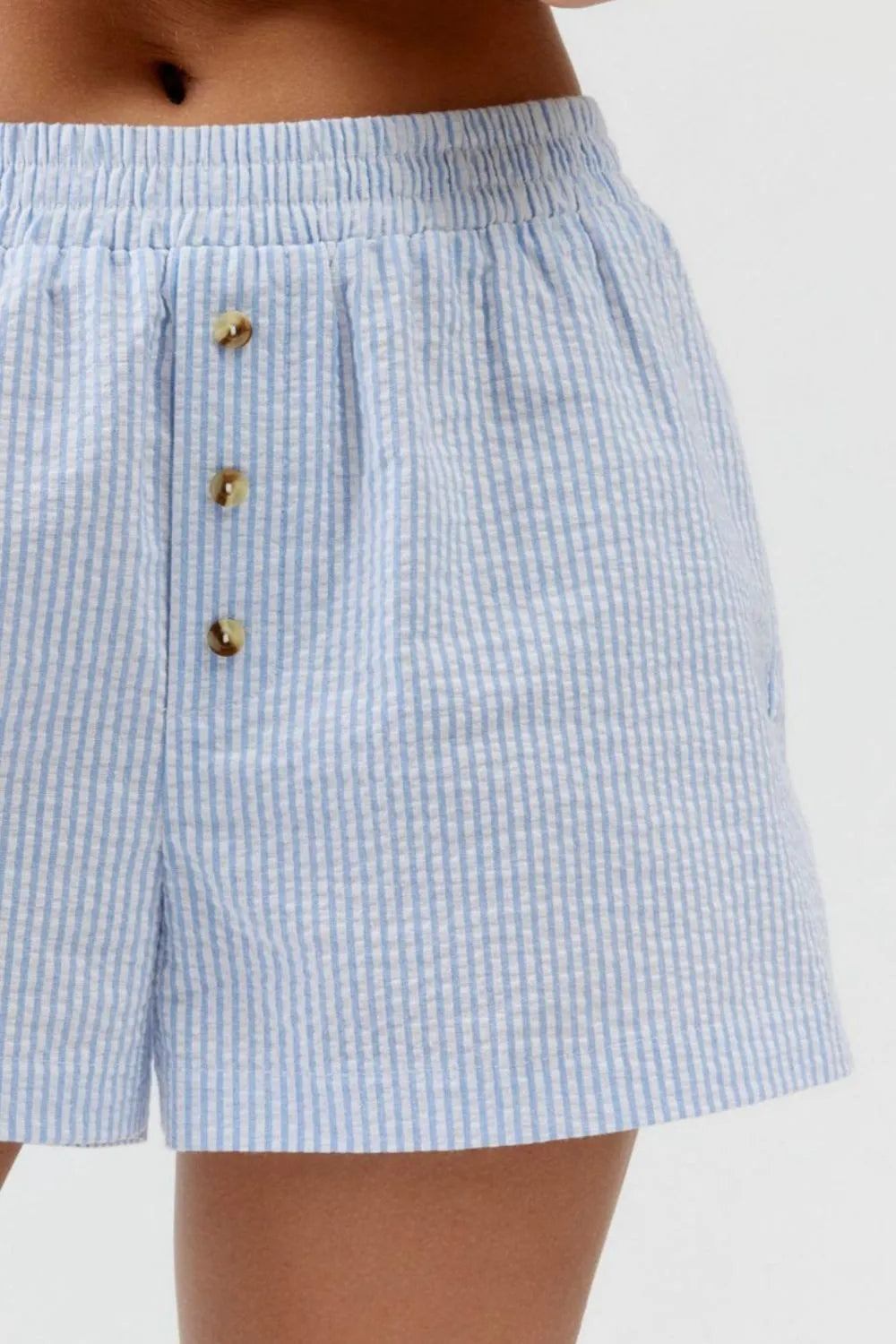 Pale blue striped shorts showing gathered waist and button-front detail