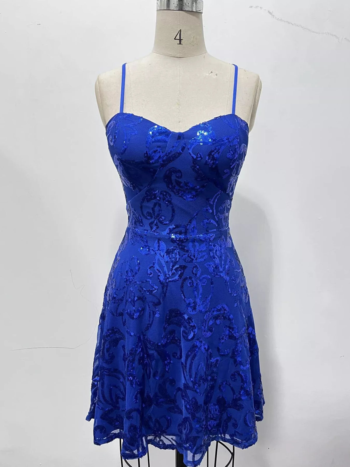 Royal blue floral-sequin mini dress displayed on a dress form.