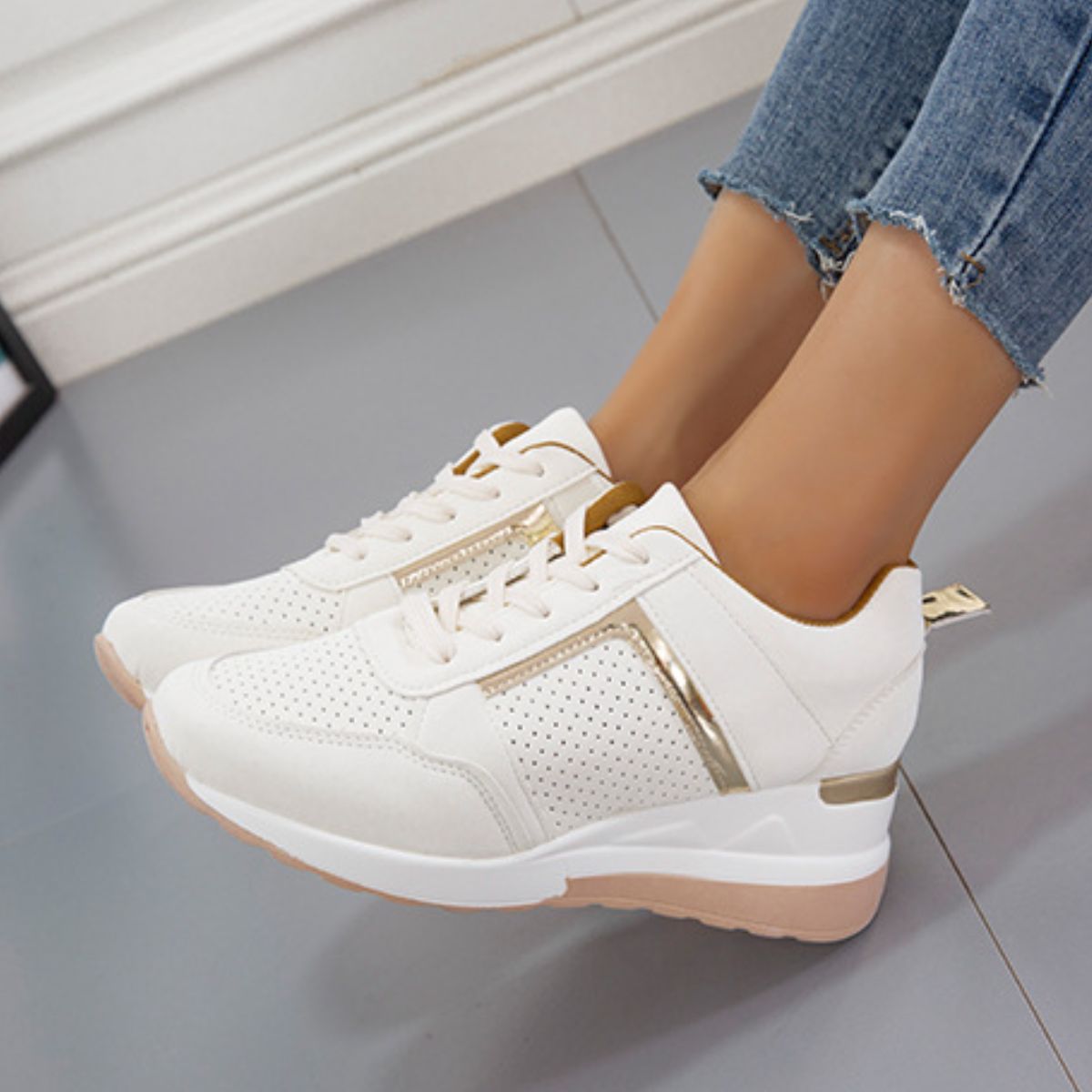 Close side view of white wedge sneaker with lace-up front