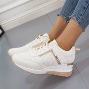 Close side view of white wedge sneaker with lace-up front