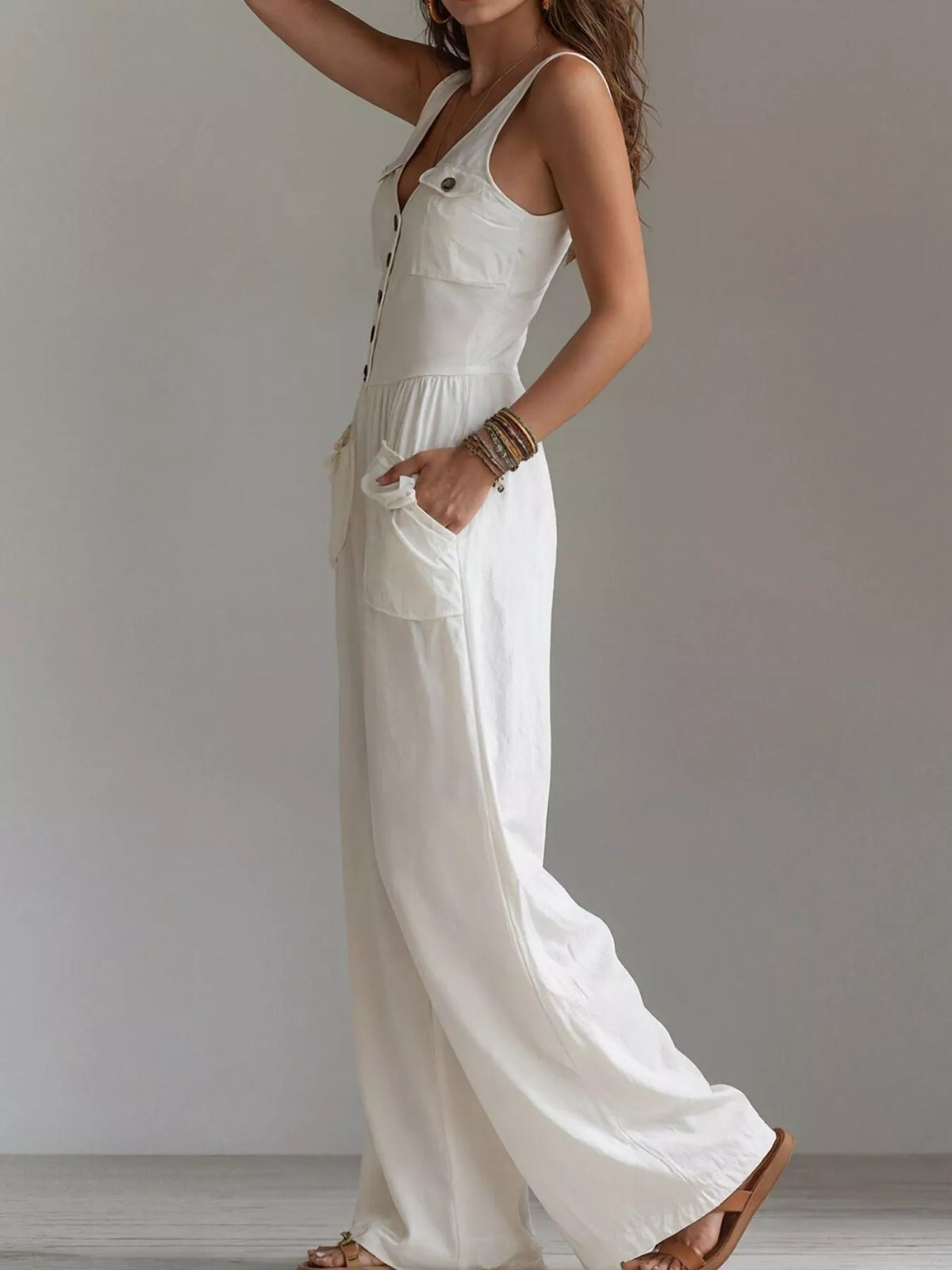 Side view of white sleeveless jumpsuit with wide legs