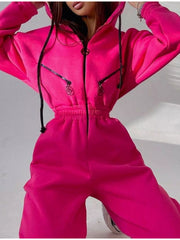 Women's bright pink hooded jumpsuit, model close-up showing zip front and waist