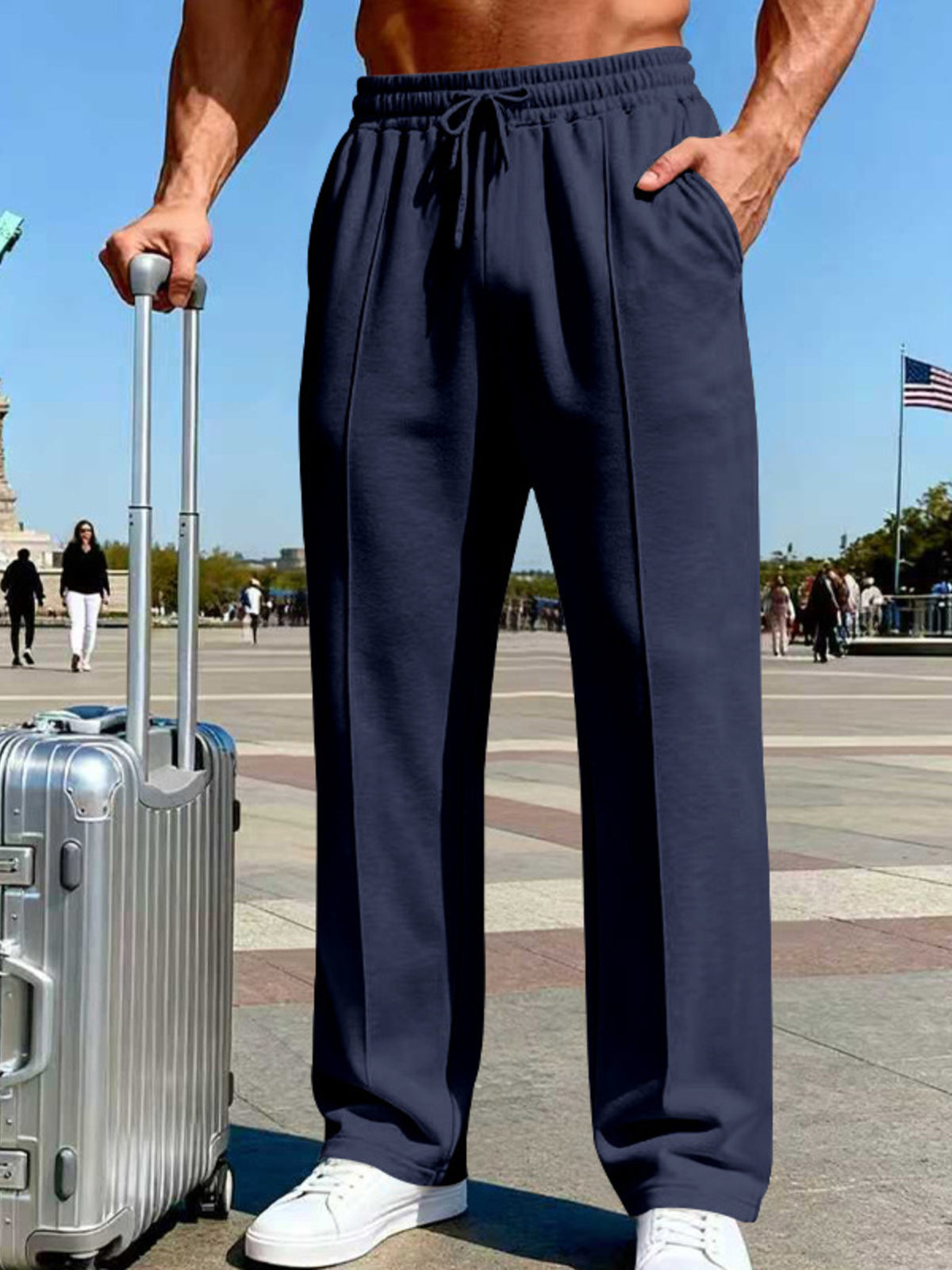 Front view of navy wide-leg pants beside a rolling suitcase near the Eiffel Tower.