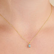 Pale blue rectangular pendant on a fine gold-tone chain worn at the neckline