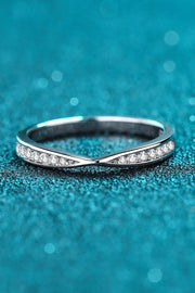 Low side view of a narrow pavé ring against teal.