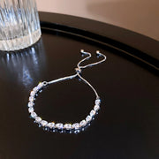 Silver-tone adjustable bracelet with a row of clear square zircon stones displayed on a dark surface