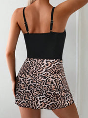 Black swimsuit and leopard-print wrap skirt, rear view showing adjustable shoulder straps