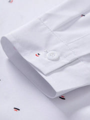 Close-up of white shirt sleeve cuff showing its button and printed motif