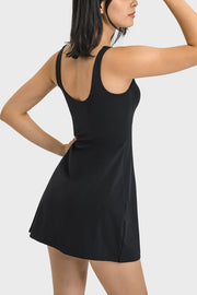 Angled back view of the black tank dress with a low scoop back.