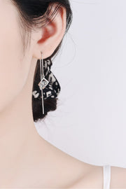 Model wearing a long silver-tone chain threader earring