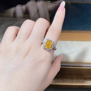 Yellow geometric center stone ring worn on a hand, viewed from above