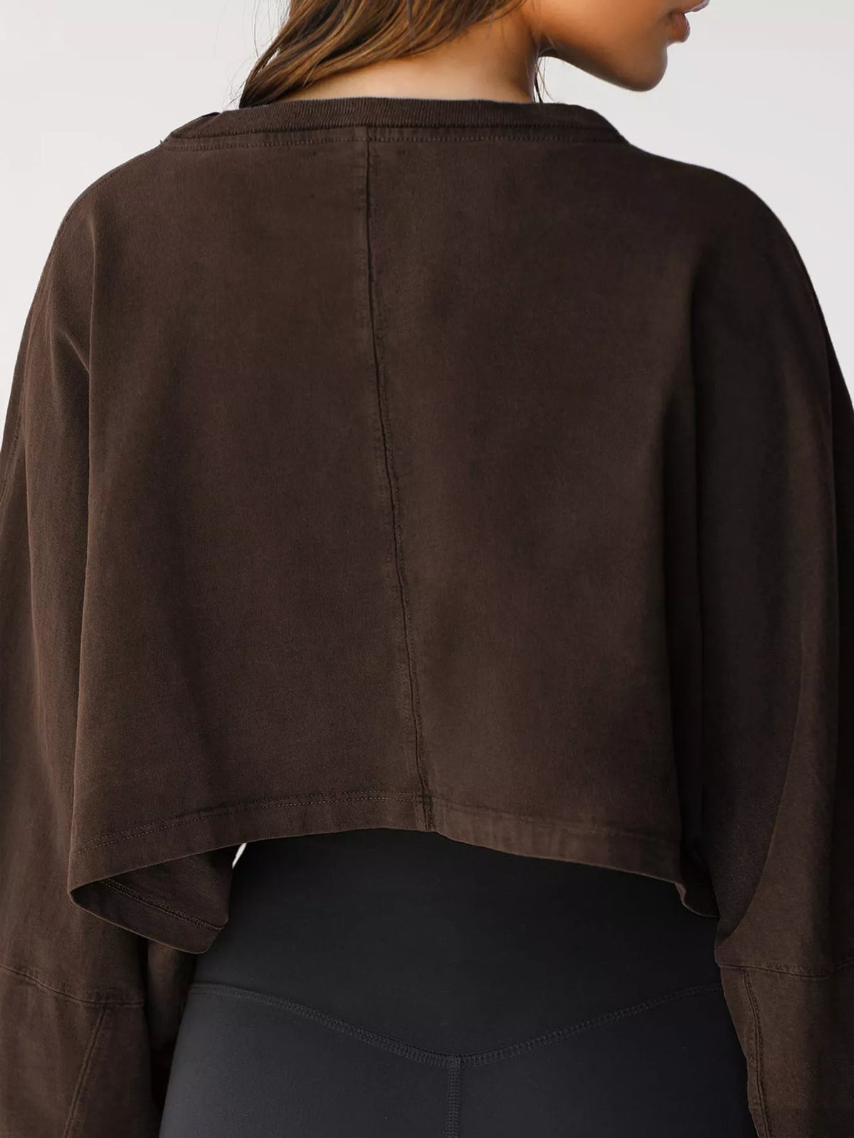 Back view of a dark brown cropped sweatshirt with long sleeves.