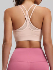 Back view of pale pink active bra with crossed double straps and wide underband