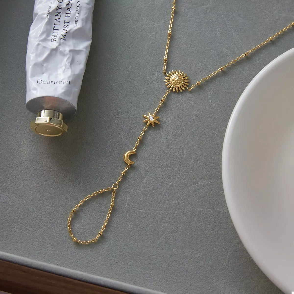 Gold sun charm bracelet arranged in a circular shape